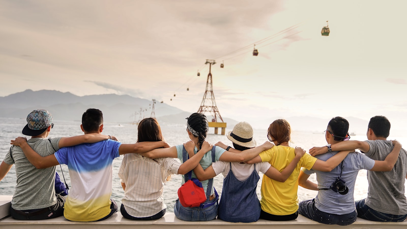 Group of friends sitting close together outdoors, laughing and talking