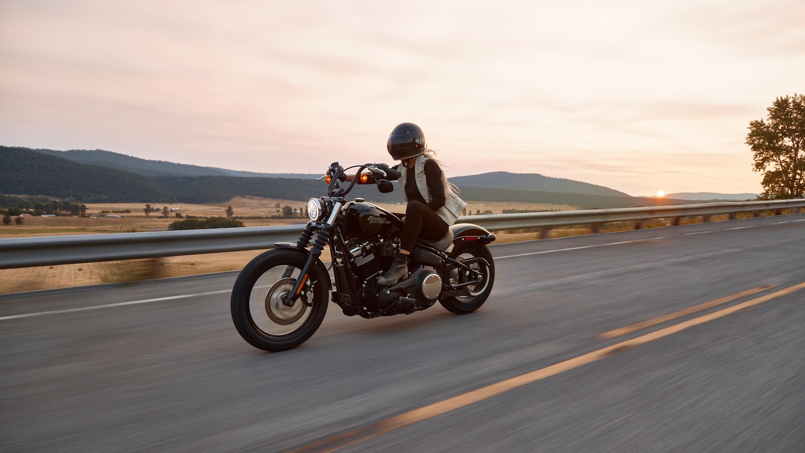 Chrome motorcycle parked on an open road with a long stretch of asphalt behind it