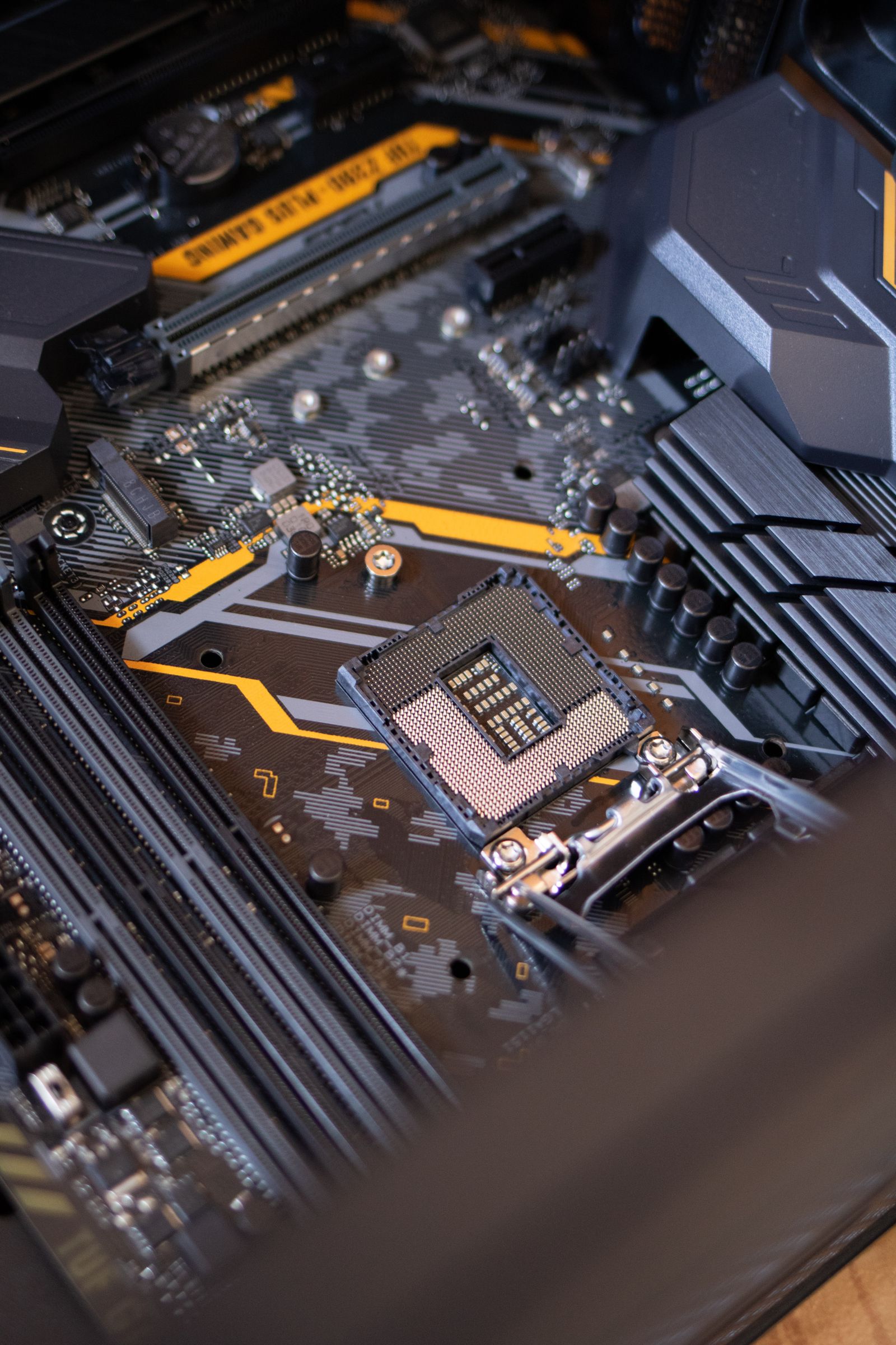 Empty CPU socket at the center of a black-and-yellow motherboard, pin grid facing up