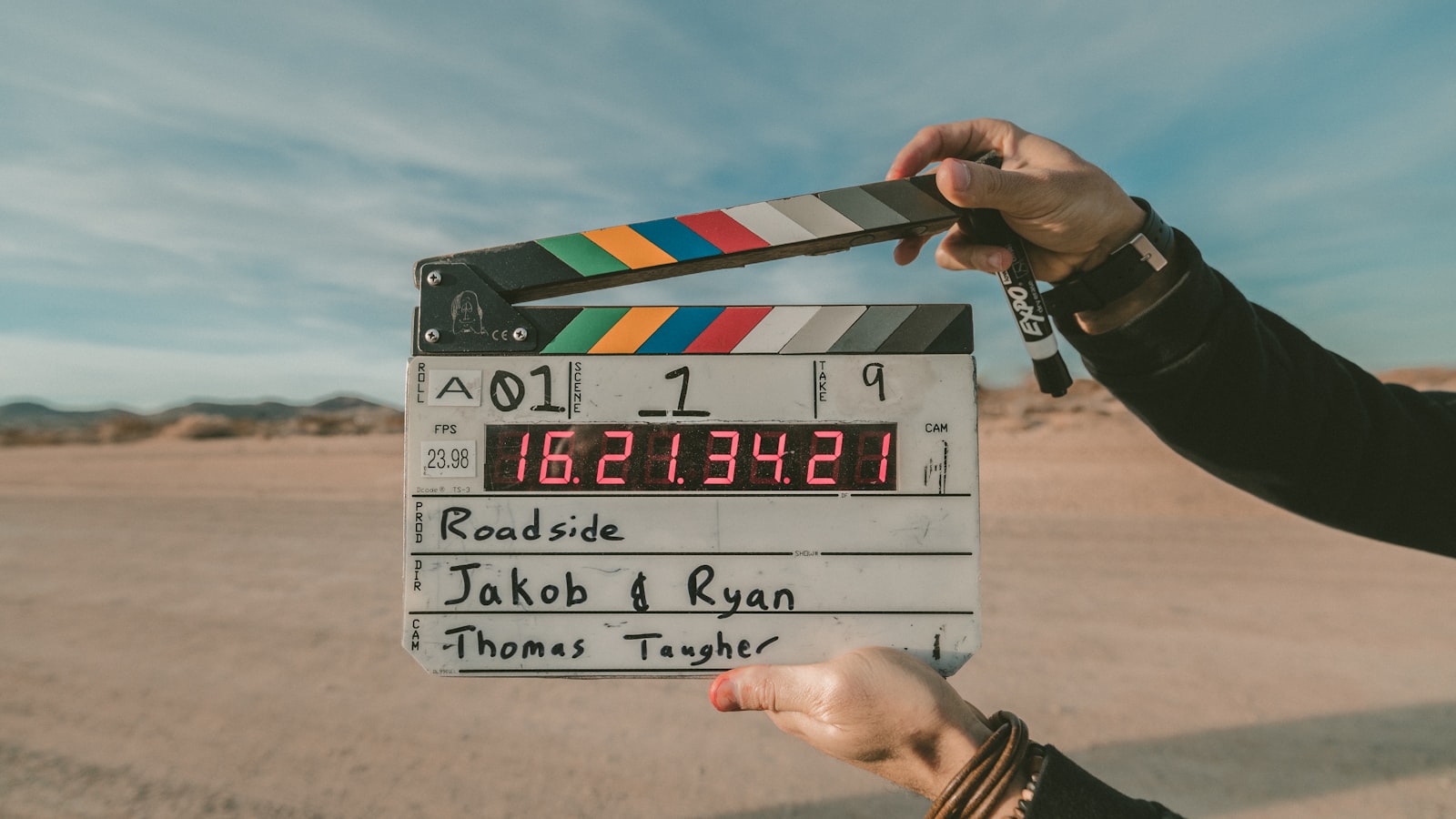 Black-and-white film clapperboard held in front of a cinema camera on a production set